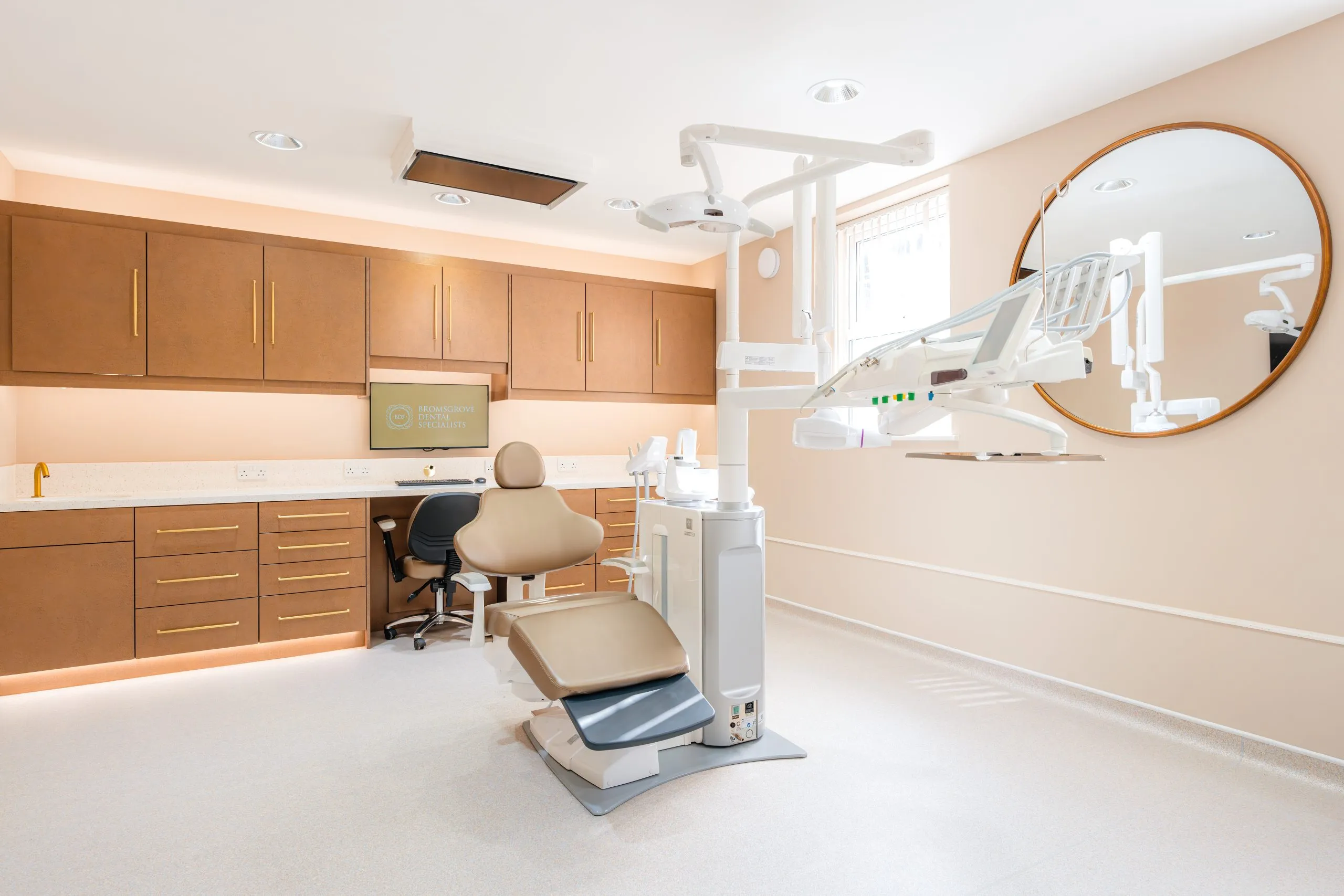 Dental chair and tan cabinetry in a completed surgery at Bromsgrove Dental Specialists